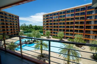 a balcony with a view of a hotel and a swimming pool at Boho Apartment in Mai Khao Beach