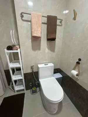 a bathroom with a white toilet and towels at Boho Apartment in Mai Khao Beach