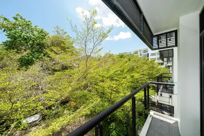a balcony with a view of trees and a building at Peaceful Bliss With 120 Sqm Kamala Beach in Kathu