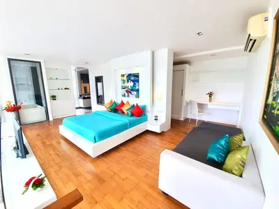 a bedroom with a blue bed and a couch at Beautiful Modern Penthouse Kamala Beach in Kamala Beach