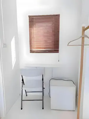 a white room with a chair and a window at XX BAO Patong Beach Phuket - เบา ป่าตอง in Patong Beach