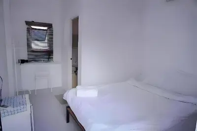 a white bedroom with a bed and a window at XX BAO Patong Beach Phuket - เบา ป่าตอง in Patong Beach