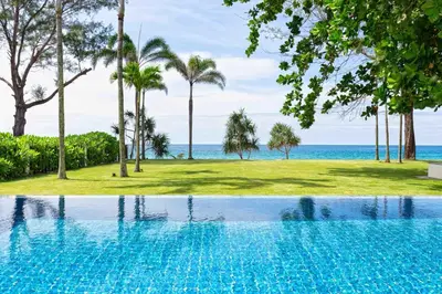a swimming pool with the ocean in the background at Villa Sand in Pilai Beach