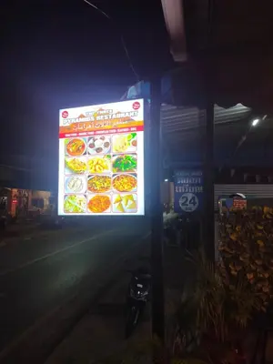 a sign for a restaurant at night at the three pyramids in Rawai Beach