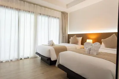 a hotel room with two beds and a window at XL PATONG Hotel in Patong Beach