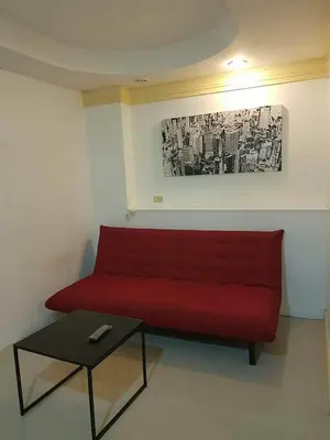 a red couch in a room with a table at Sea Breeze Patong Holiday Condo in Patong Beach