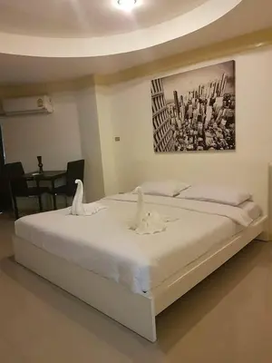 a bedroom with a white bed with swans on it at Sea Breeze Patong Holiday Condo in Patong Beach
