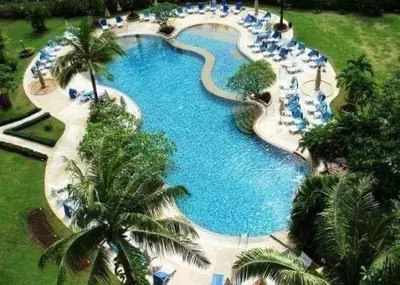 an overhead view of a large swimming pool with palm trees at Sea Breeze Patong Holiday Condo in Patong Beach