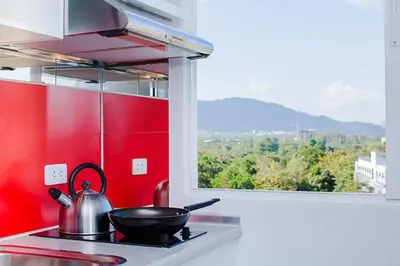 a kitchen with a stove with a frying pan and a window at W Phuket in Phuket Town