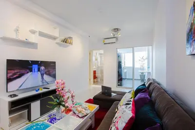 a living room with a couch and a flat screen tv at W Phuket in Phuket Town