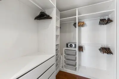 a walk in closet with white walls and white cabinets at Coastal Villa on Fairway in Phuket