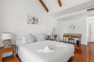 a bedroom with a white bed with two hats on it at Coastal Villa on Fairway in Phuket