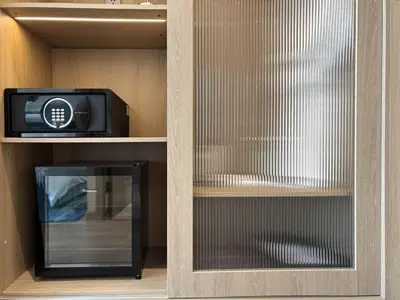 a glass cabinet with a tv and a microwave at Laya Suites and Residences in Bang Tao Beach