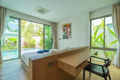 a bedroom with a desk and a large window at 2BR Pool Villa at Shambhala in Laguna Bangtao in Bang Tao Beach