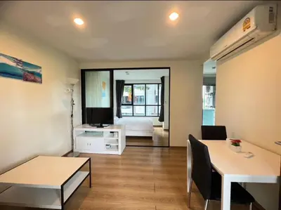 a small room with a bed and a desk and a table at Centrio condo near central Phuket in Ban Rangeng