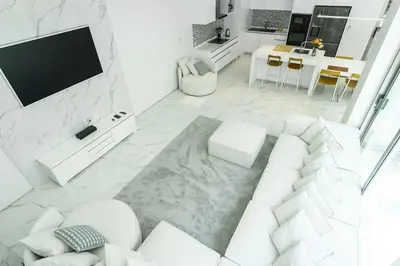 a white living room with a white couch and a tv at Luxury Villa Residence near Laguna in Ban Pak Lak