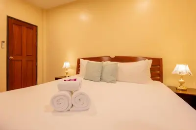 a bedroom with a white bed with towels on it at Kamala Beach House, 7-Min Walk to Beach in Kamala Beach