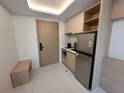 a small kitchen with a refrigerator and a table at Kamala Apartments in Kamala Beach