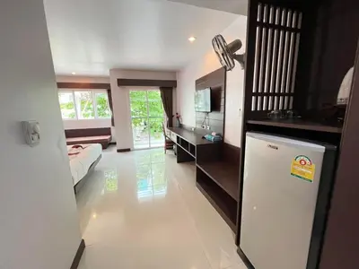 a living room with a refrigerator and a bedroom at Chollada inn kamala in Kamala Beach