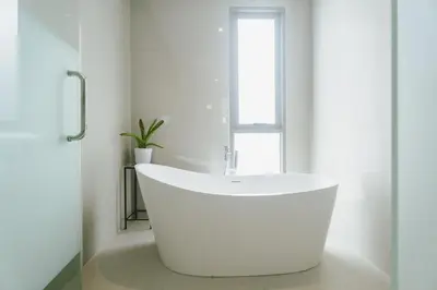 a white bath tub in a bathroom with a window at Teak 5 BR Pool Villa Bang Tao Airport Shuttle in Laguna Phuket
