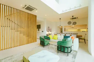 a living room with a white couch and green chairs at Teak 5 BR Pool Villa Bang Tao Airport Shuttle in Laguna Phuket