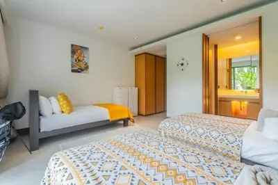 a bedroom with two beds and a mirror at Elegant Beachfront 3BR Condo at Pearl of Naithon in Nai Thon Beach