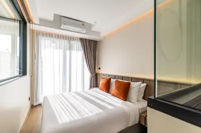 a hotel room with a bed and a window at P Villas Patong in Patong Beach