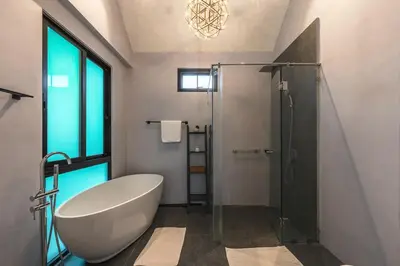 a bathroom with a tub and a glass shower at V188 The Granary Loft Haven 3BR Pool Sanctuary in Bang Tao Beach