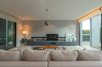 a living room with a couch and a tv at V188 The Granary Loft Haven 3BR Pool Sanctuary in Bang Tao Beach