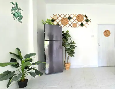 a stainless steel refrigerator in a room with potted plants at Village Beach House I in Patong Beach