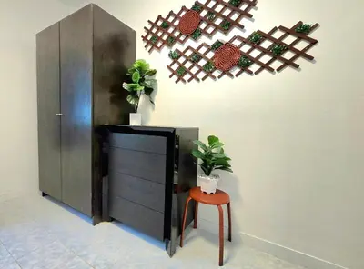 a room with a cabinet and a stool with potted plants at Village Beach House III in Patong Beach