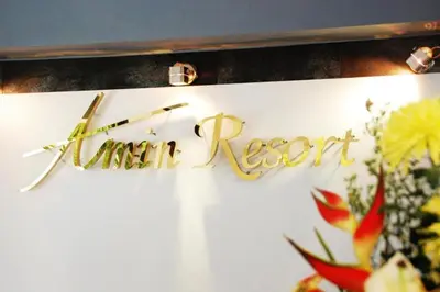 a sign for a restaurant on a wall with flowers at Amin Resort in Ban Thalat Choeng Thale