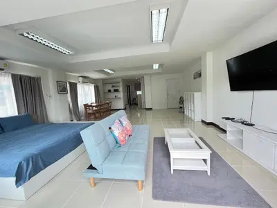 a bedroom with a bed and a couch and a tv at TONY Central Stay in Phuket Town