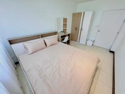 a bedroom with a large bed with a pink pillow at TONY Central Stay in Phuket Town
