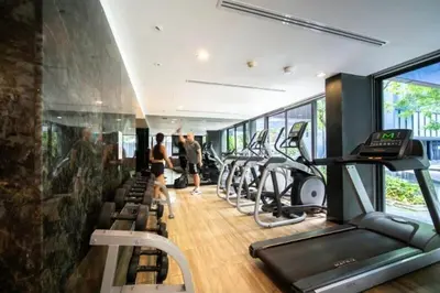 a gym with a row of treadmills and cardio machines at \u8d85\u4fbf\u5229 199\u53f7\u82ad\u4e1c\u6d77\u6ee9\u7cbe\u88c5\u516c\u5bd3 5\u5206\u949f\u5230\u6d77\u6ee910\u5206\u949f\u5230\u9152\u5427\u8857 in Patong Beach
