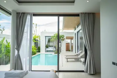 a bedroom with a view of a pool and a villa at Mouana Residence Song Khun Chalong VIP4-bedroom Pool Villa 89-14 in Chalong