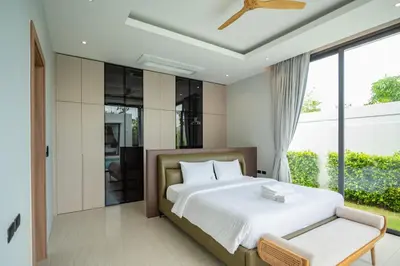 a bedroom with a bed and a large window at Mouana Residence Song Khun Chalong VIP4-bedroom Pool Villa 89-14 in Chalong
