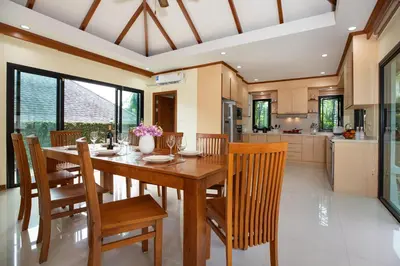 a kitchen and dining room with a wooden table and chairs at Balinese-Style 3Bedrooms Villa Tina in Kata Beach