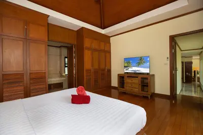 a bedroom with a bed and a flat screen tv at Balinese-Style 3Bedrooms Villa Tina in Kata Beach