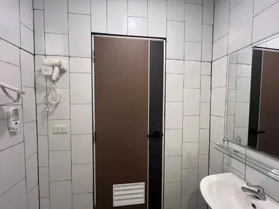 a bathroom with a brown door and a sink at Anda Mantham Hill in Ban Bang Rong