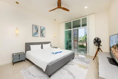 a bedroom with a white bed and a tv at Oxygen Villas with Private Pool Near Naiharn by TropicLook in Rawai Beach