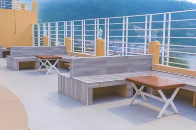 a balcony with benches and tables on a building at Bellevue Ocean Patong in Patong Beach