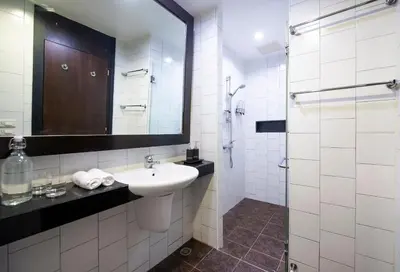 a white bathroom with a sink and a mirror at Lokal Phuket 
