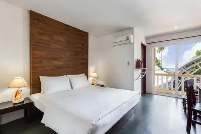 a bedroom with a large white bed and a balcony at PP Insula in Phi Phi Don