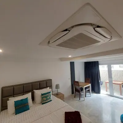 a bedroom with a large bed and a table at Andaman Seaview house rooftop in Patong Beach