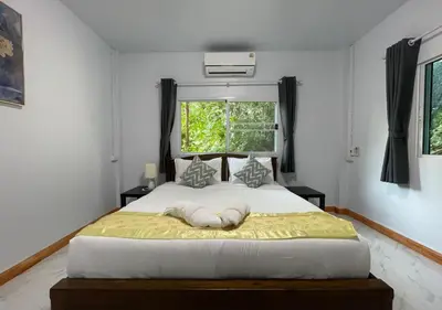a bedroom with a large white bed with a window at Amazing Seaview 2-Bedroom House in Patong in Patong Beach
