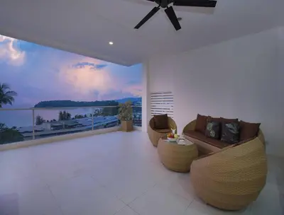 a living room with couches and a view of the ocean at Oceanview Kata Penthouse - Pasifora in Kata Beach
