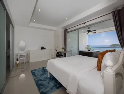 a bedroom with a white bed and a view of the ocean at Oceanview Kata Penthouse - Pasifora in Kata Beach