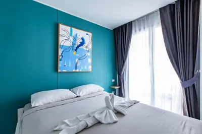 a blue bedroom with a bed and a window at Pool View 1 Bed Apt T2-620 in Chalong
