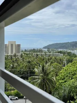 a view of palm trees from a balcony at veloche group 2 in Karon Beach